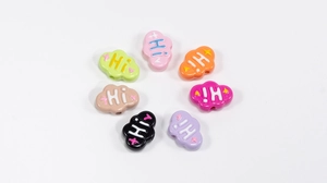 Macro detail of colorful cloud-shaped DIY beads with Hi lettering and side threading holes