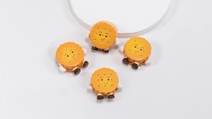 Macro detail of acrylic sandwich cookie pendants with cute cartoon faces for DIY jewelry