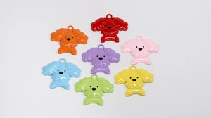 Flat lay of colorful dog charms in seven bright shades on a white background