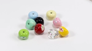 Macro shot of colorful acrylic apple-shaped DIY beads with center holes for jewelry making