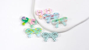 Detailansicht bunter Acrylperlen in Schleifenform für DIY Handyketten und Bastelbedarf