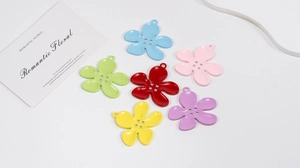 Detailed view of colorful four-eye floral pendants with metallic finish and top hanging rings