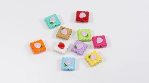 Macro shot of colorful acrylic strawberry biscuit charms for DIY jewelry and keychains