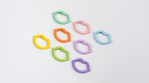 Flat lay of colorful lip-shaped spring ring carabiners in eight vibrant lacquered colors
