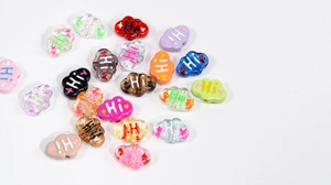 Close-up of colorful cloud-shaped acrylic beads with Hi lettering for DIY jewelry making