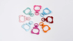 Macro shot of colorful bear-shaped metal lobster clasps with rotating rings for DIY crafts