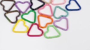 Detalle de mosquetones de aluminio coloridos con forma de corazón para accesorios