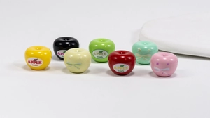 Detailed view of colorful apple-shaped acrylic beads with polish finish and star patterns