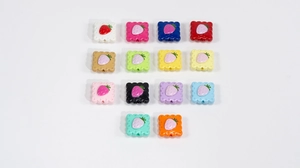 Flat lay of colorful acrylic strawberry soda biscuit beads for DIY jewelry making and crafts