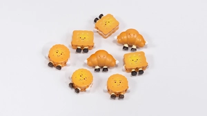Close-up of cute cartoon bread and cookie acrylic charms with happy smiling faces