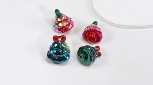 Close-up of resin Christmas tree charms with metallic glaze and DIY threading holes