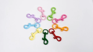 Close-up of colorful spray-painted metal snap hooks with 360-degree rotating swivel base