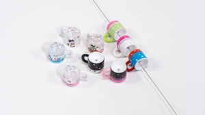 Macro detail of mini cup-shaped acrylic beads with cartoon cat patterns for DIY crafts