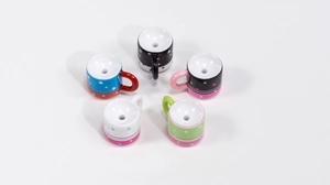 Detail of five mini acrylic milk cup beads with star patterns for DIY jewelry making