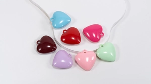 Dettaglio di ciondoli a cuore in acrilico in colori pastello per creazione gioielli fai-da-te