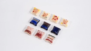 Close-up of assorted acrylic cat pillow beads with cartoon bear patterns for DIY jewelry