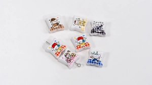 Detail showing white acrylic pillow-shaped beads with cute cartoon dog prints for DIY crafts