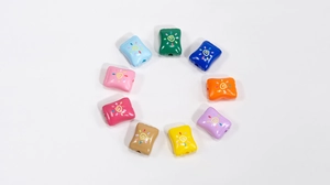 Detailed view of colorful acrylic candy-style beads with hand-drawn sun patterns