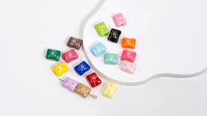 Detailed macro view of colorful square acrylic beads with sun patterns for DIY jewelry