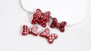 Detailed view of assorted resin butterfly charms in red and pink for DIY jewelry making