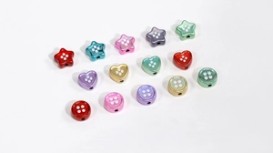 Detalle macro de cuentas acrílicas de colores con forma de estrella y corazón para DIY