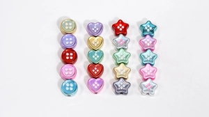 Detalle macro de cuentas acrílicas de colores en forma de estrella y corazón DIY