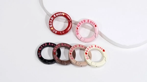 Detail van ronde springringen met Good Luck gravure in diverse snoepkleuren