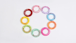 Macro-opname van kleurrijke ronde veerringen met Good Luck-gravure voor tasaccessoires