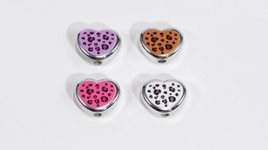 Détail de quatre breloques cœur imprimé léopard avec cadre en métal pour bijoux DIY