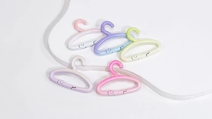 Détail de cinq mini connecteurs cintres colorés avec finition nacrée aux tons macaron