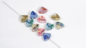 Detailed view of colorful patchwork patterned acrylic triangle beads for DIY crafts