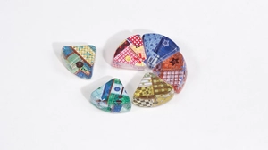 Close-up of fan-shaped acrylic beads with colorful patchwork patterns and side holes