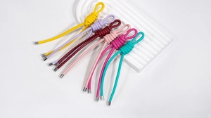 Détail macro de pendentifs de clés en cuir tressé multicolore avec embouts métalliques