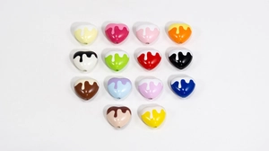 Macro shot of 14 colorful acrylic heart beads with white drip glaze for DIY jewelry making