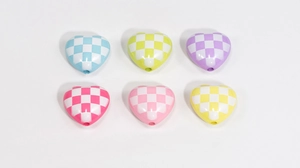 Macro shot of colorful checkered acrylic heart beads for DIY jewelry and necklaces