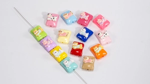 Macro detail of colorful resin beads in pillow shapes with cute cartoon animal designs