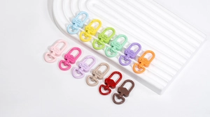Dettaglio di dodici moschettoni a molla a forma di cuore con ganci girevoli colorati