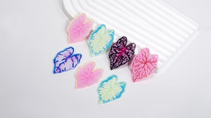 Détail de breloques feuilles en acrylique coloré avec nervures fines pour bijoux DIY