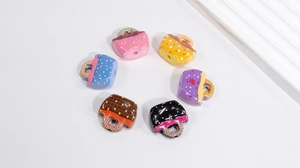 Macro shot of colorful acrylic purse charms with heart and polka dot patterns for DIY crafts