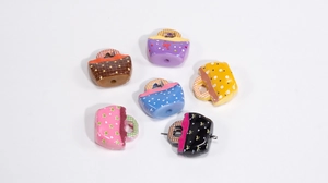 Macro detail of acrylic handbag charms with colorful polka dots and bow patterns for DIY crafts