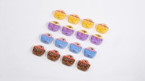 Macro detail of acrylic basket-shaped beads with star and polka dot patterns for DIY crafts