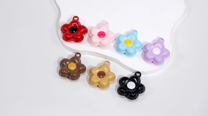 Close-up of colorful glossy flower charms with hanging holes for DIY craft accessories