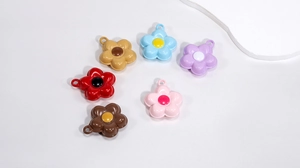 Detailed view of colorful five-petal flower charms for DIY jewelry and keychain accessories