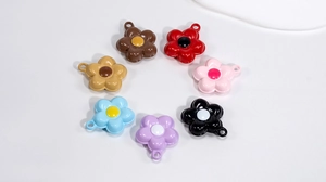 Flat lay of colorful enamel flower charms with hanging loops for DIY jewelry making