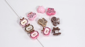 Close-up of leopard print acrylic beads in apple and cherry shapes for DIY jewelry making