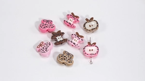 Detailed view of leopard print acrylic beads in cherry and bitten apple shapes for DIY crafts