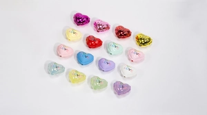 Makroansicht von herzförmigen Acrylperlen mit HOT LOVE-Gravur für DIY-Schmuck
