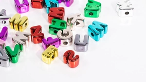 Close-up of metallic acrylic alphabet beads with a shiny mirror finish for DIY crafts