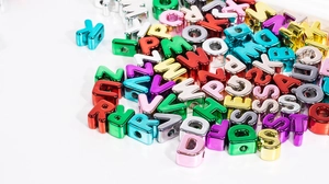 Macro shot of colorful metallic acrylic letter beads for DIY jewelry and crafts