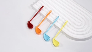 Detail of colorful golf club shaped spoons in red orange blue and yellow on white tray